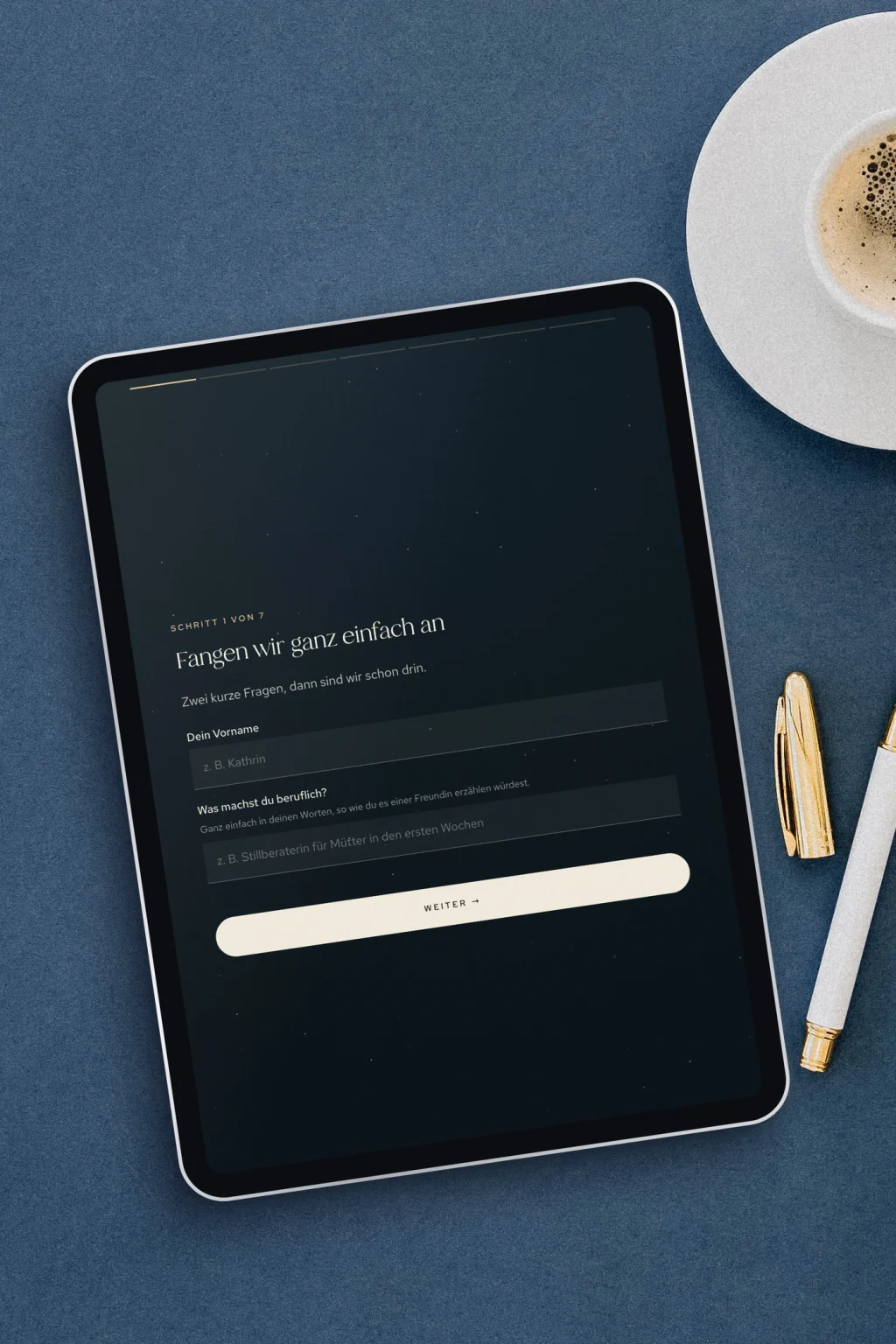 Tablet mit dem „Über Mich“ Text Wizard auf einem blauen Schreibtisch mit Espresso und Goldstift